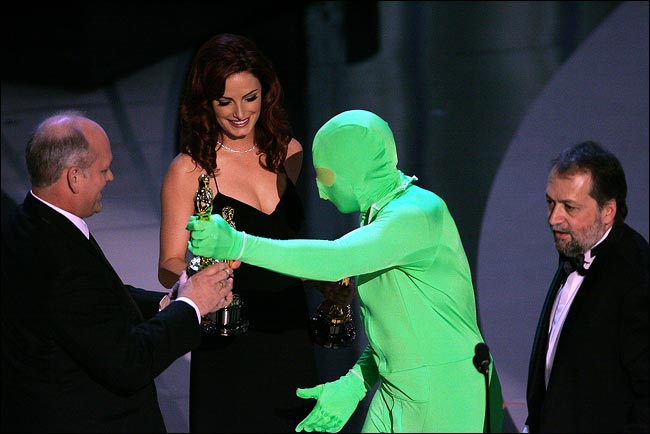 Man dressed in green suit presenting an Academy Award