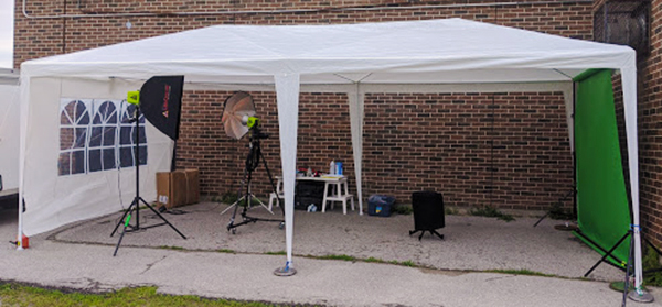 Outdoor green screen photo setup under a white tent