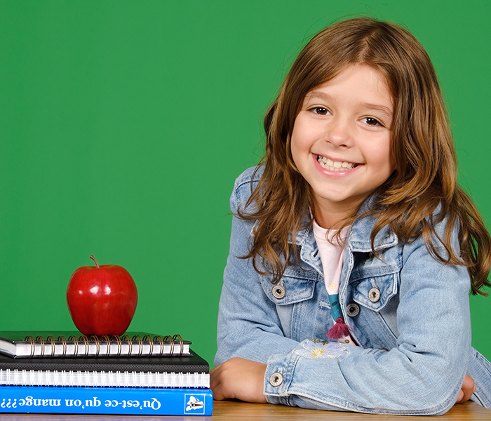 Girl at desk with a green screen background