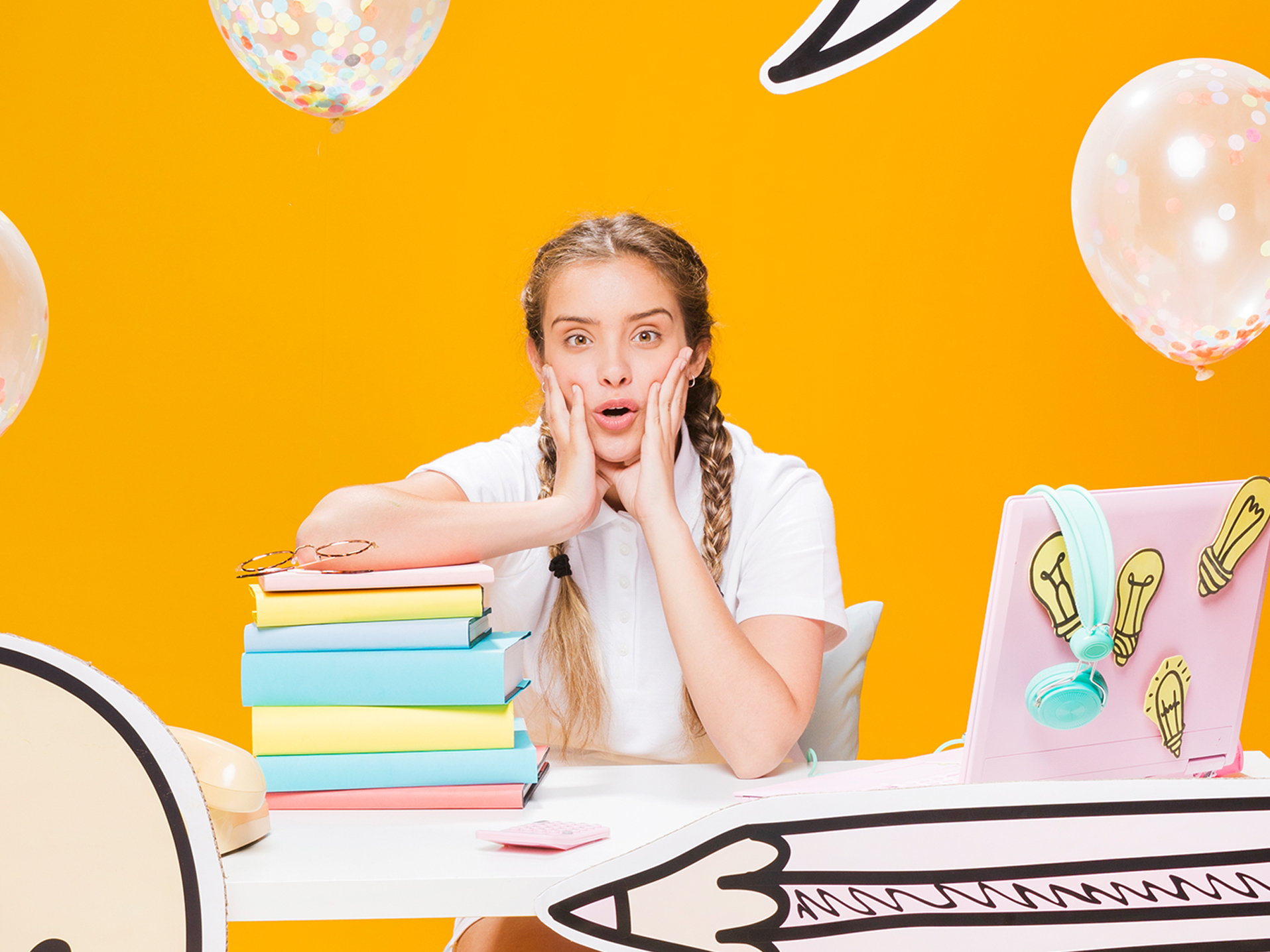 School girl sitting at a desk surrounded by props