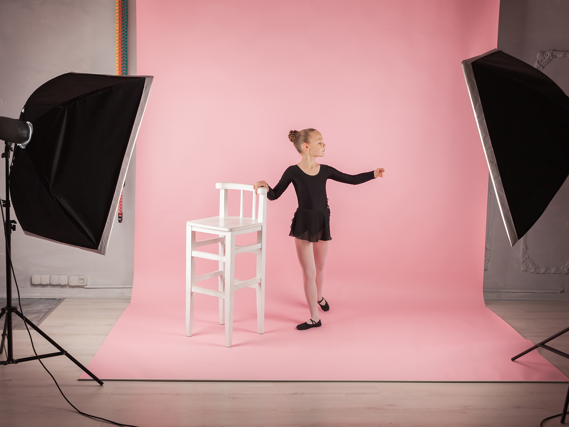 Professional Studio Photography setup with a young dancer on a pink sweep background posing for a photoshoot