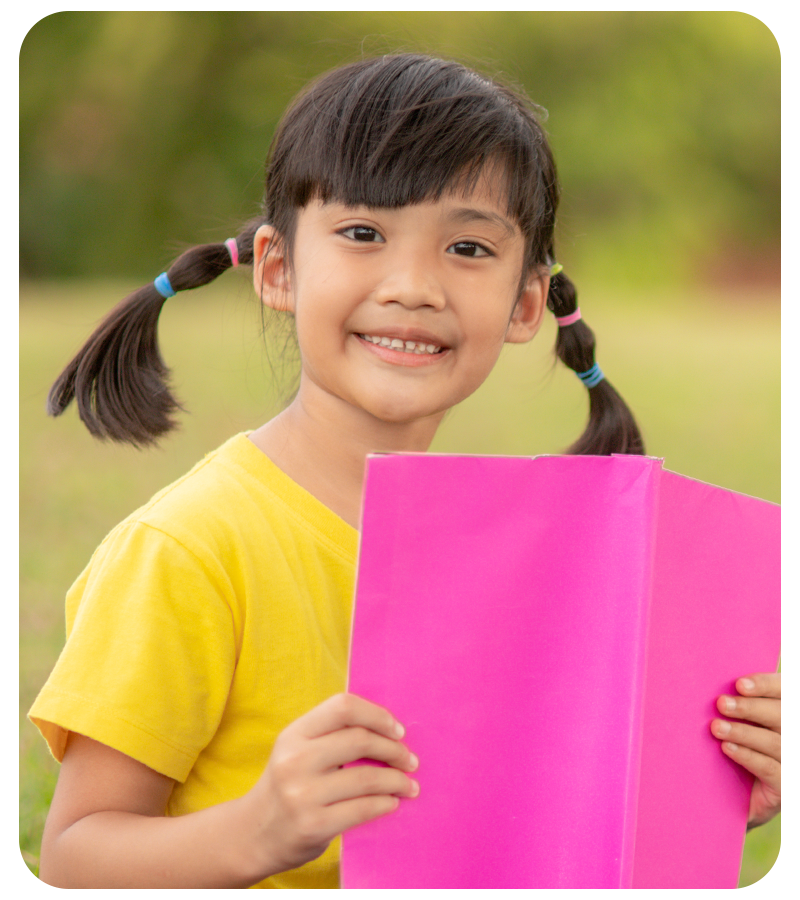 A vibrant portrait of a school girl holding a book after being color corrected by 36Pix